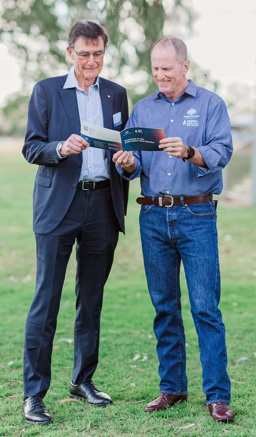 Sir Angus and Andrew holding the 2026 Basin Plan Review roadmap booklet
