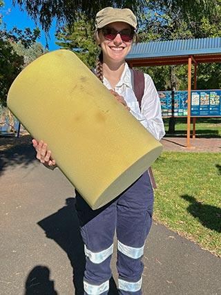 Person holding large cylinder of foam, designed to clean iron pipes